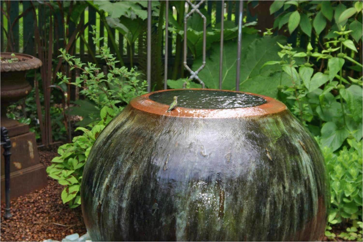 Look closely and you'll see a delicate hummingbird enjoying the fresh water of this fountain.